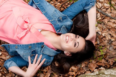 Young woman lying on the forest floor,