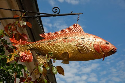 Fish sculpture on an old fisherman's house, Historic fishing village Holm