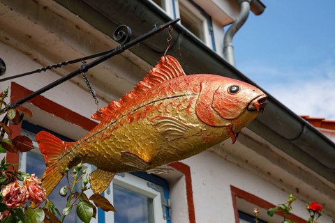 Fish sculpture on an old fisherman's house, Historic fishing village Holm