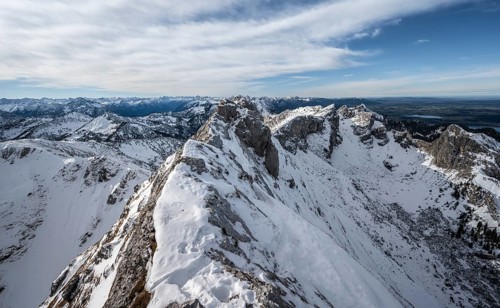 Rocky snow-covered mountain ridge of the Ammergauer Hochplatte, behind peak Kraehe