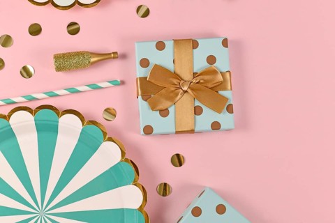 Party flat lay with teal blue paper plates, gift box