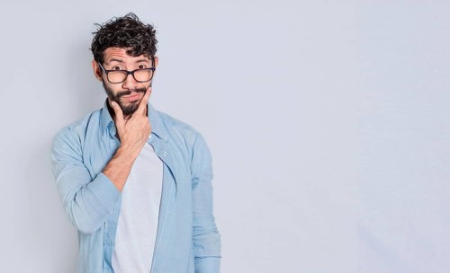 Handsome man rubbing his beard with a doubtful expression, Person rubbing his chin with a doubtful expression. handsome bearded man with doubt expression isolated