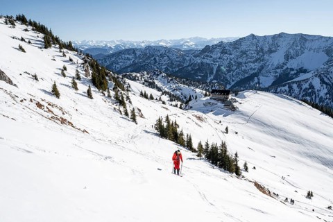Ski tourers on ski tour on the Rotwand, behind mountain hut Rotwandhaus with mountain panorama