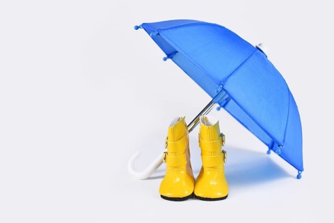 Rain concept with blue umbrella and yellow rubber boots,