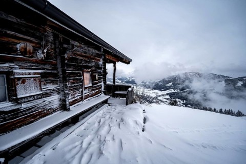 Snowfall, mountain hut in the snow
