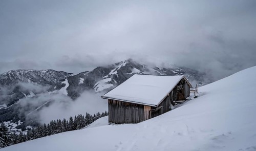 Snowfall, mountain hut in the snow