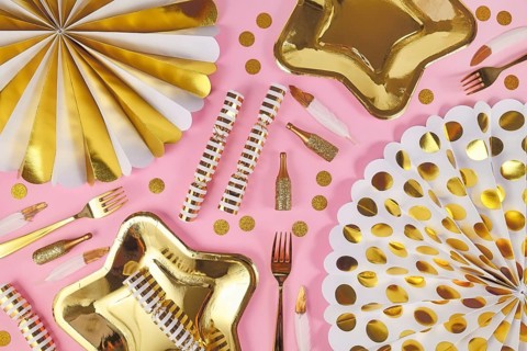 Party flat lay with golden and white decoration on pink background,
