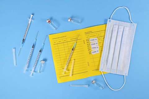 Concept for Corona virus booster vaccination showing vaccine passport with 4 entries,