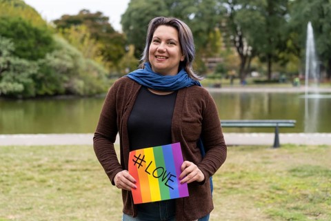Love. Cheerful queer woman holding a message supporting the LGBT community,
