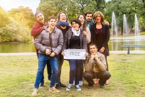 Pride. Cheerful queer group holding a message supporting the LGBT community,