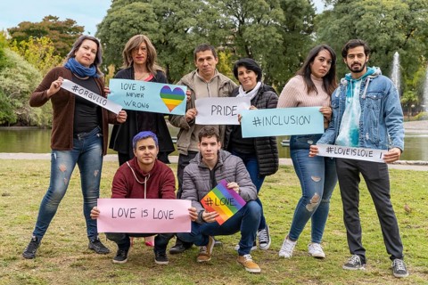 Cheerful queer group holding a message supporting the LGBT community,