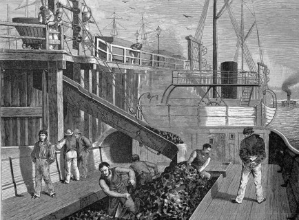 Loading of a coal steamboat in a harbour in England, coal is shovelled into the storage bunker