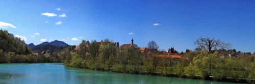 The Lech near Fuessen with a view of the Benedictine monastery of St. Mang and high castle. Ostallgaeu Swabia, Bavaria