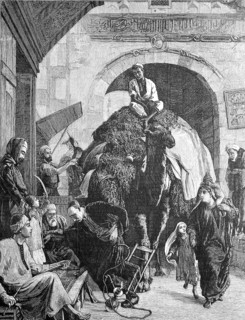 A street in cairo, a merchant with a loaded camel rides through the gate