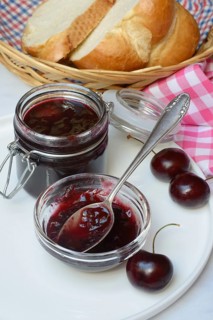 Cherry jam in small bowl with spoon, Black cherries