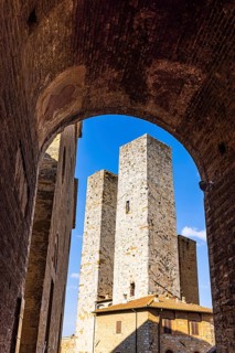 Gender towers and medieval archway against a blue sky, San Gimignano