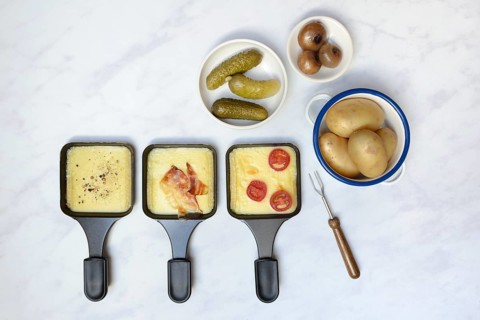 Raclette, melted raclette cheese in pans and ingredients