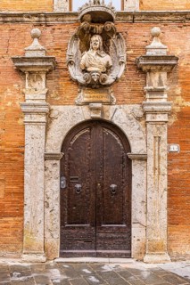 Historic round arched house entrance gate of a palace, framed with columns of light marble