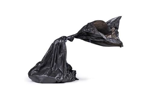 Black plastic dog poop bag on white background,