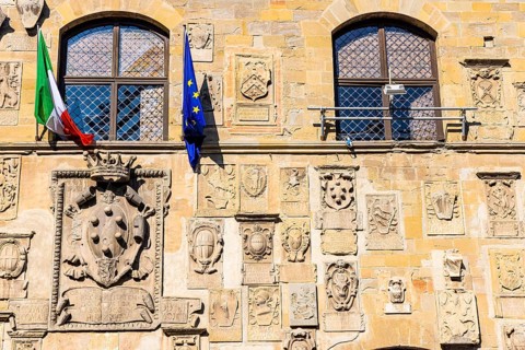 The Italian and European flags fly on the facade of Palazzo Pretorio, Arezzo