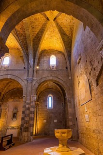 The illuminated ceiling vault of Sovana Cathedral, below the baptismal font