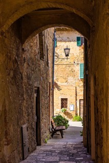 Archway and old stone houses in Monticchiello, Tuscany