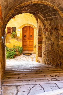 Arched passageway with view of a house entrance door, Petroio