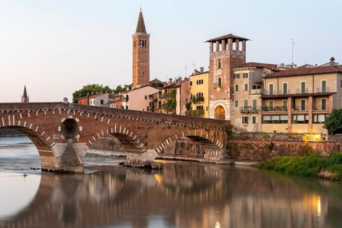 Arched bridge Ponte Pietra, spans the river Adige