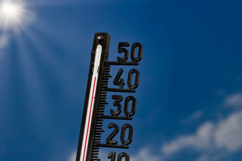 Symbolic image of the heat wave, thermometer at 45 degrees and sun rays