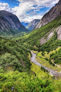 View from above of the forested valley Eikesdalen, high mountains and the river Aura