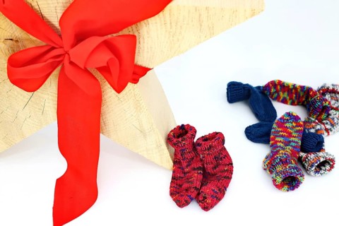 Christmas wooden star with a red bow isolated against a white background, Self-knitted socks on the side