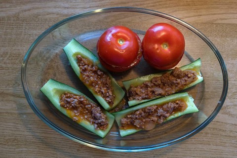 Stuffed peppers and tomatoes in a glass casserole on a wooden table, Bavaria