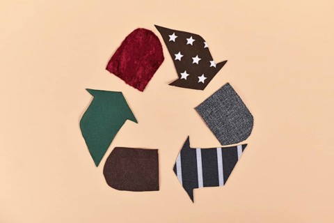 Recycling arrow symbol made from old textile pieces,