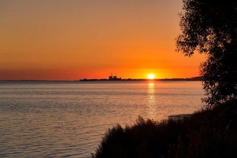 Sunset at Lomma Bay, chimneys of the decommissioned Barsebaeck nuclear power plant on the horizon