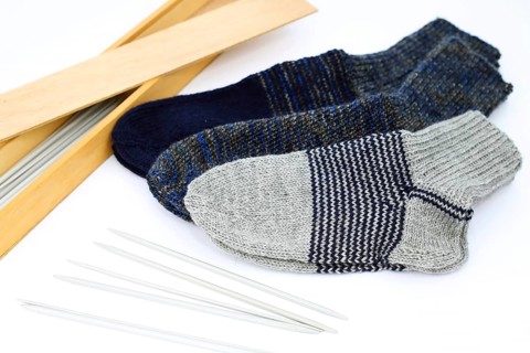 Self-knitted socks made of wool isolated against a white background. In different colours and sizes,