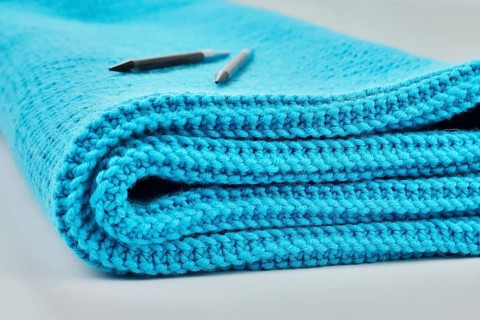 Knitted wool blanket in the colour magenta,