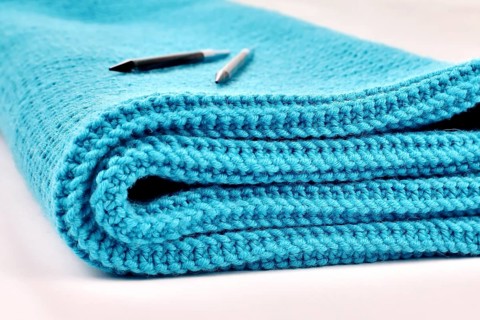 Knitted wool blanket in the colour magenta,