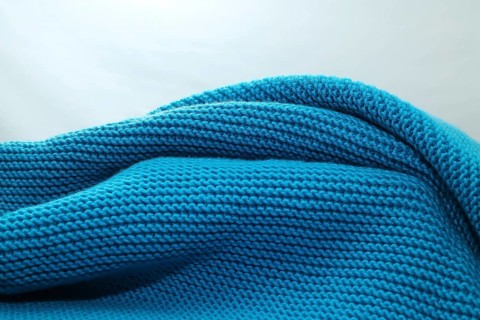 Knitted wool blanket in the colour magenta,