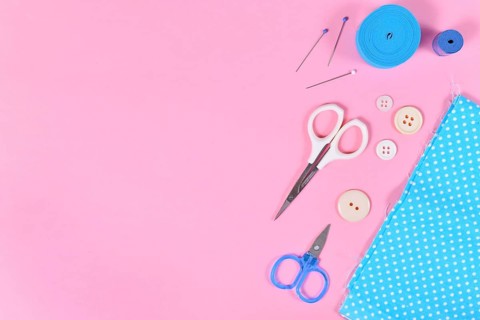 Flat lay with various sewing tools like fabric, scissors