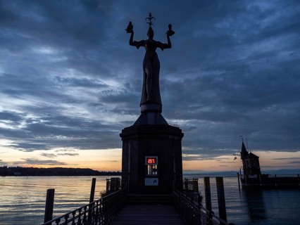 Statue of Imperia at the harbour entrance of Constance in the morning light in front of sunrise, Old Town