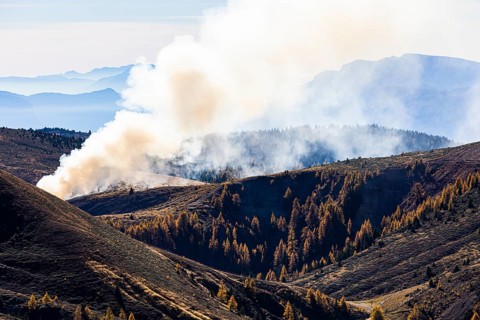Rising smoke in autumnal landscape, skiing and hiking area Merano 2000