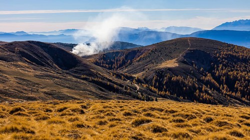 Rising smoke in autumnal landscape, skiing and hiking area Merano 2000