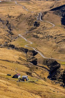 Winding hiking trail, in front a small mountain hut