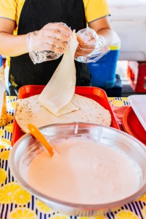 Preparation of Nicaraguan QUESILLO, traditional Central American food quesillo. Hands making a Nicaraguan quesillo. Close up of hands making a traditional quesillo with pickled onion