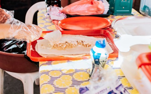 Homemade Nicaraguan quesillo, traditional large quesillo food. Hands making a Nicaraguan quesillo. Close up of hands making a traditional quesillo with pickled onion