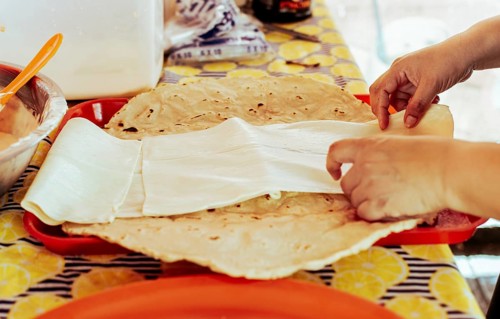 Preparation of Traditional Nicaraguan Quesillo. Person making delicious Nicaraguan cheese. Traditional cheese with pickled onion, Hands preparing the traditional Nicaraguan Quesillo