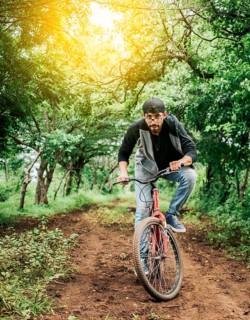 A guy riding a bike in the countryside, Person riding a bike in the countryside