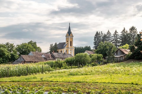 Fields and village panorama with church in a landscape, Somogyvamos