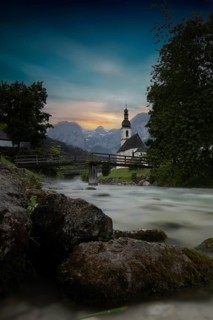 Parish church of St. Sebastian, with wooden bridge over a stream