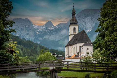 Parish church of St. Sebastian, with wooden bridge over a stream